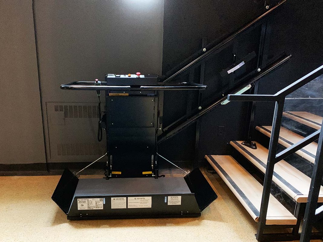 黑色 Delta 輪椅升降平台展開於校園樓梯下方